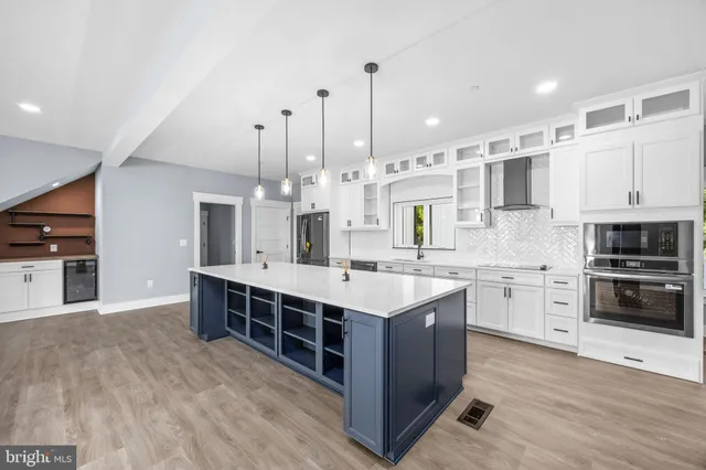 an empty room with wooden floor cabinet and windows