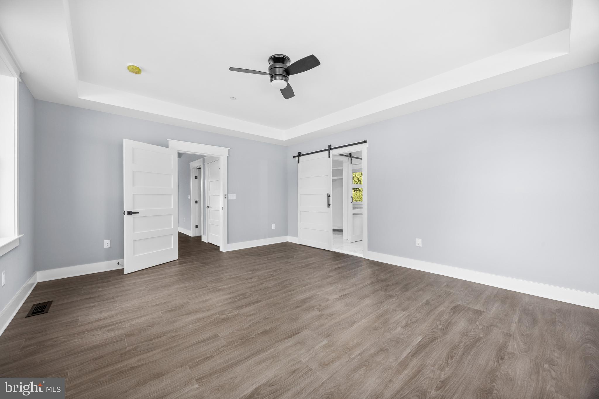 5692 King Stuart Drive Salisbury, MD 21801 - Photo 41 of 82 an empty room with wooden floor ceiling fan and windows