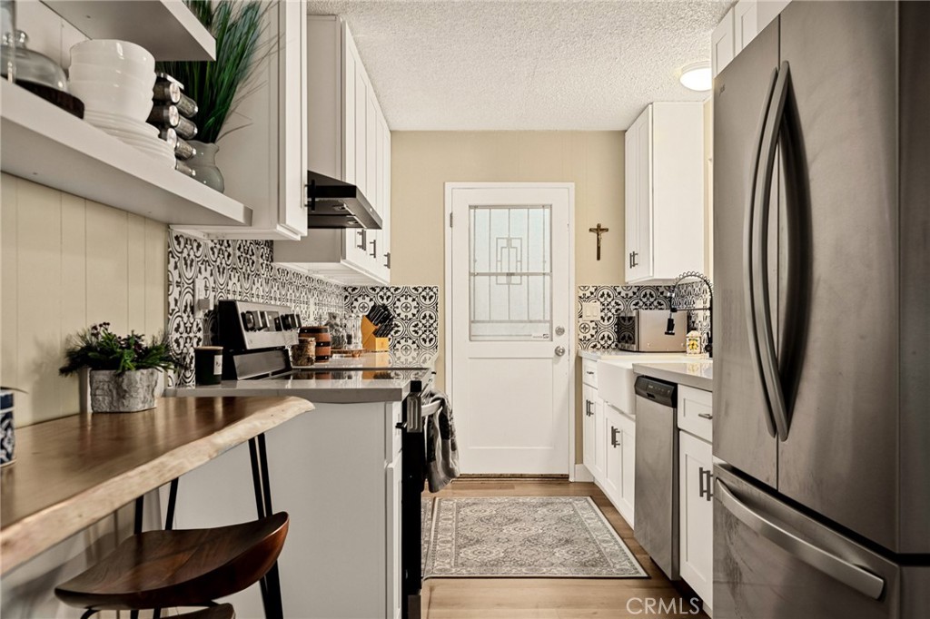 30789 All View Drive Running Springs, CA 92382 - Photo 7 of 25 a kitchen with stainless steel appliances granite countertop a refrigerator a stove and a sink