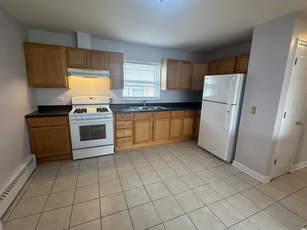 a kitchen with a stove a refrigerator and a sink