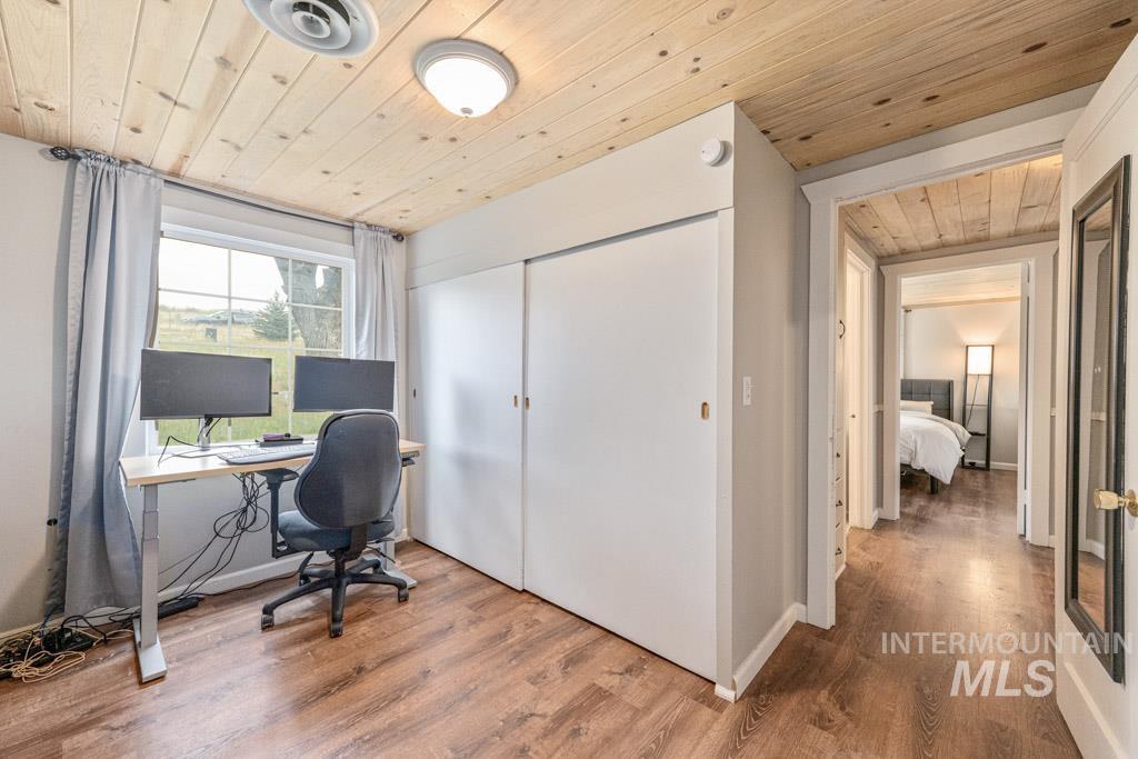 259 Highway 12 Pomeroy, WA 99347 - Photo 25 of 45 Room featuring wood-finish flooring, a wood-paneled ceiling, a window with exterior visibility, and a closet with sliding doors