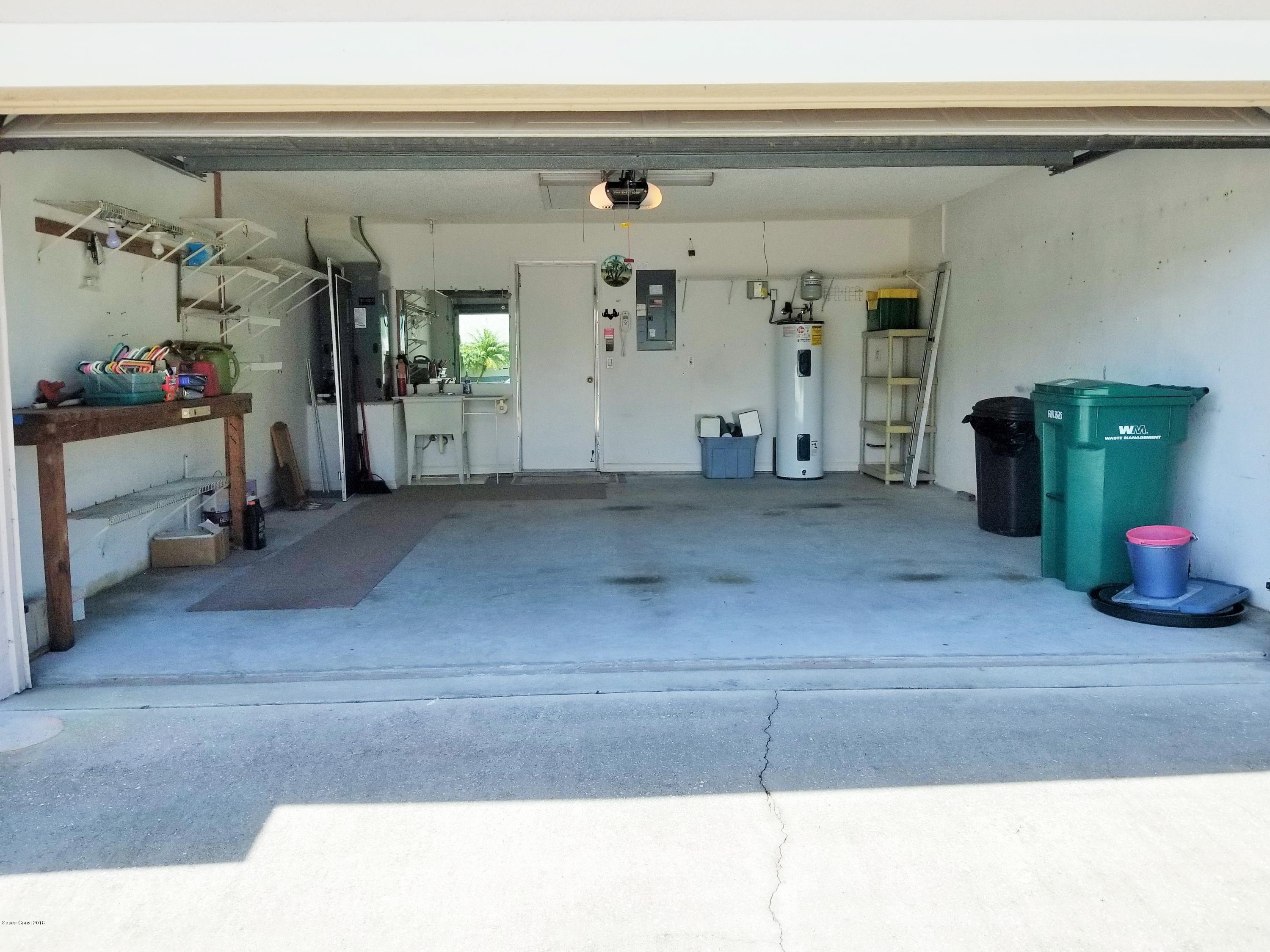 283 Twin Lakes Road Melbourne, FL 32901 - Photo 40 of 42 Garage with Work Bench and Shelving