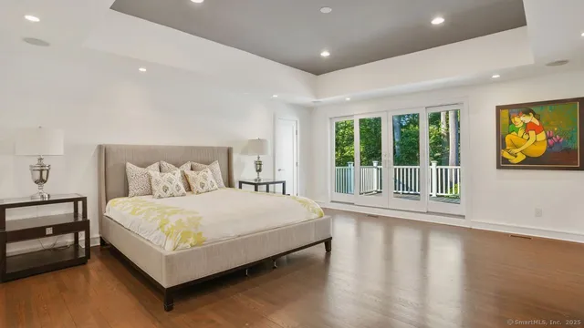 a bed sitting in a spacious bedroom next to a window