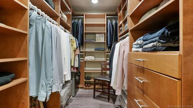 a view of walk in closet with clothes and shoes