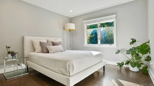 a bedroom with a bed and a potted plant