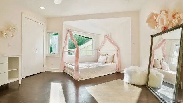 a bedroom with furniture and a large window