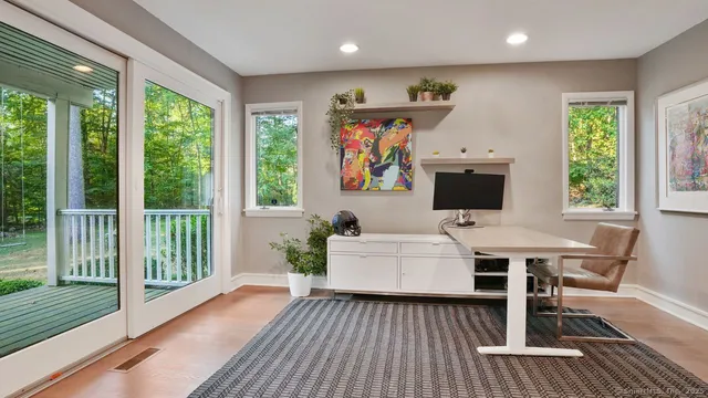 a living room with furniture a flat screen tv and a floor to ceiling window