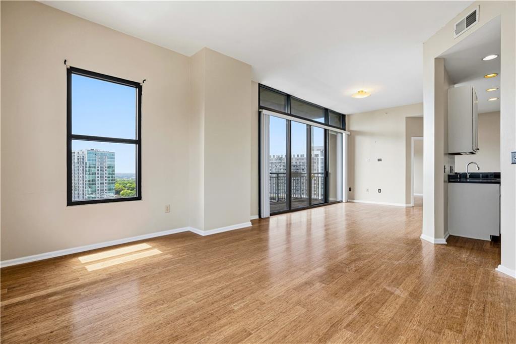3040 Peachtree Road Northwest, Unit 1503 Atlanta, GA 30305 - Photo 19 of 38 a view of an empty room with wooden floor and a window