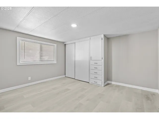 a view of an empty room with window and closet area