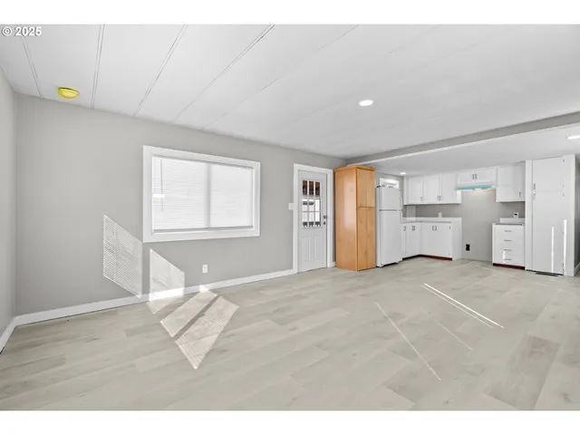 a view of empty room with wooden floor and window