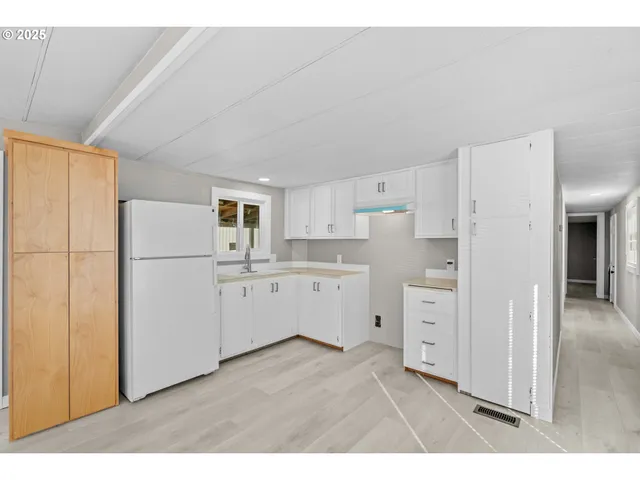 a kitchen with white cabinets and white appliances
