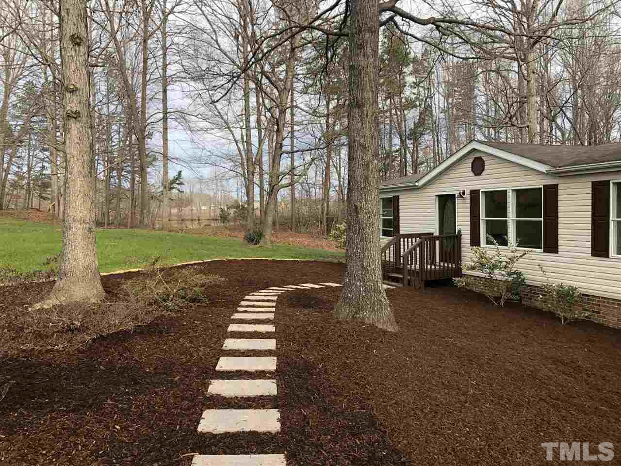 238 Dustin Lane Roxboro, NC 27574 - Photo 1 of 23 a front view of a house with a yard table and chairs