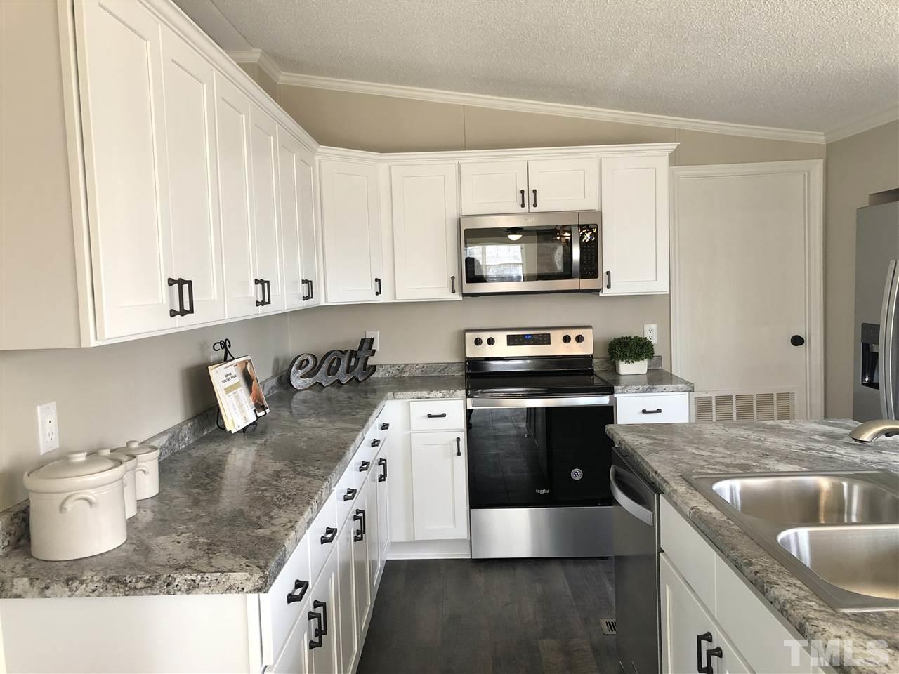 238 Dustin Lane Roxboro, NC 27574 - Photo 5 of 23 a kitchen with stainless steel appliances granite countertop a sink stove and microwave