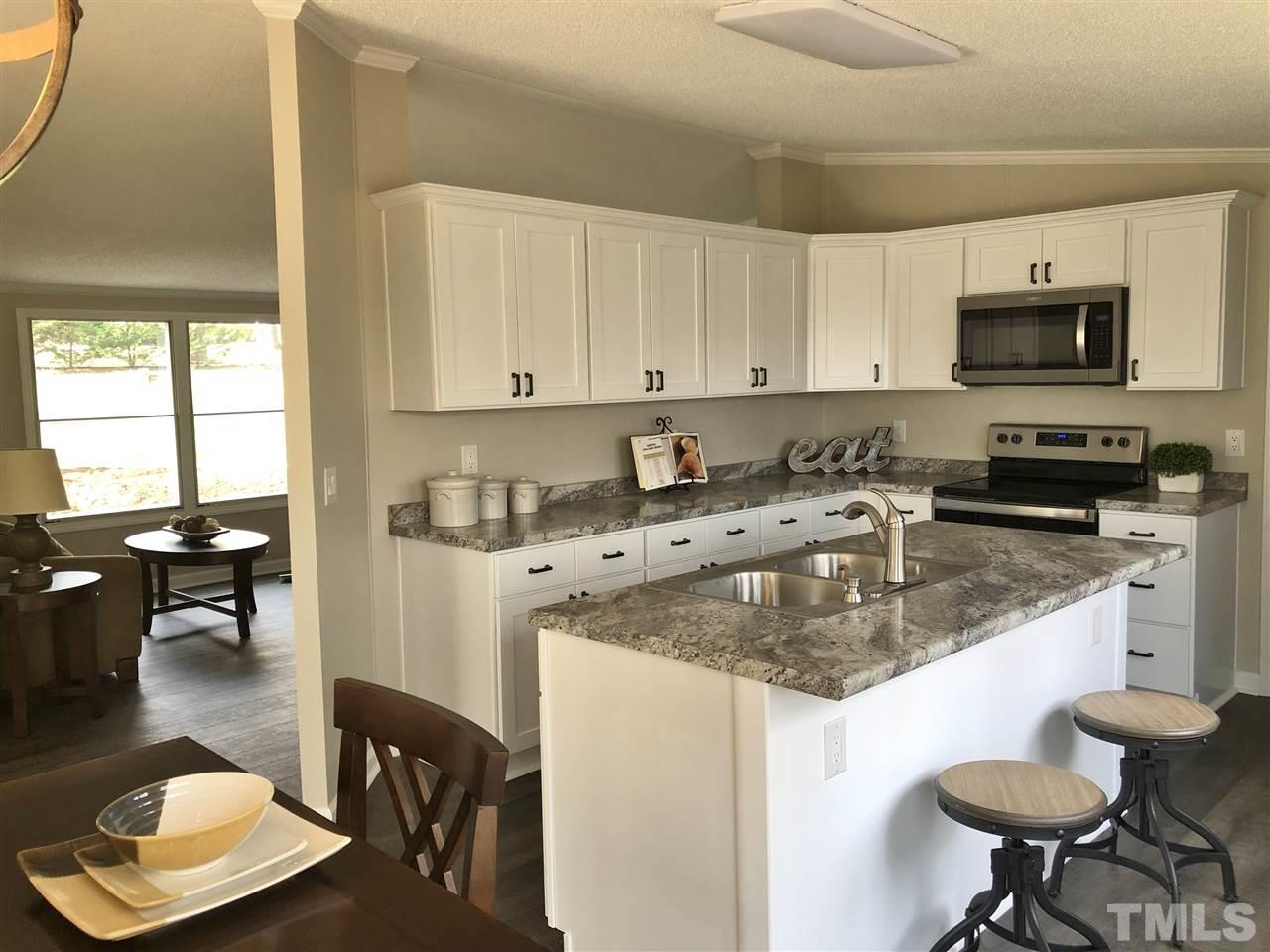 238 Dustin Lane Roxboro, NC 27574 - Photo 9 of 23 a kitchen with stainless steel appliances granite countertop a sink a stove and a refrigerator
