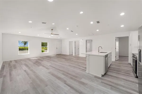 a view of a kitchen with a sink and dishwasher with wooden floor