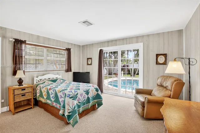a bedroom with furniture and a large window