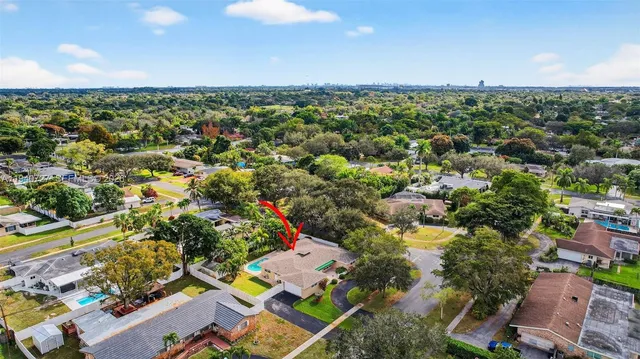an aerial view of residential houses with outdoor space and trees