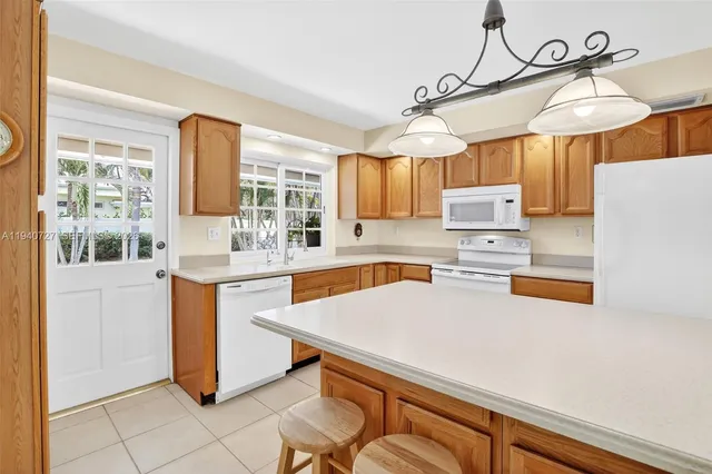 a kitchen with stainless steel appliances a sink a stove a refrigerator and cabinets