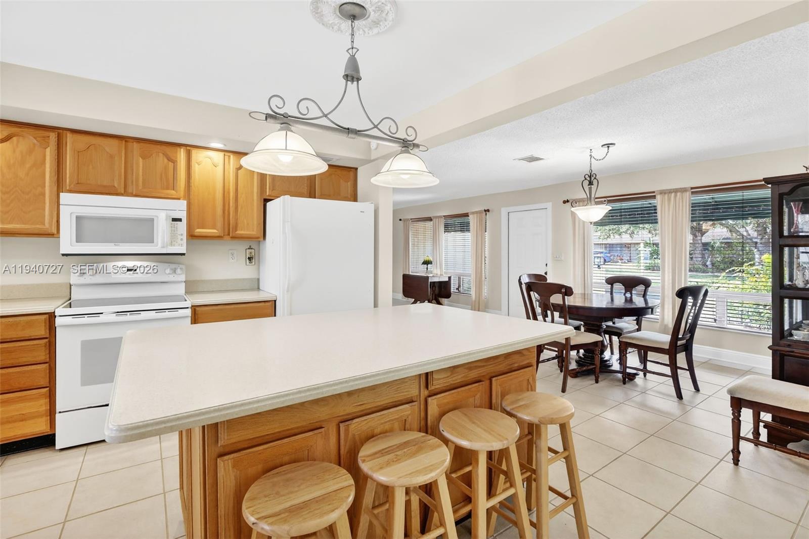 280 Southwest 63rd Avenue Plantation, FL 33317 - Photo 9 of 53 a kitchen with stainless steel appliances granite countertop a stove a sink a refrigerator a dining table and chairs with wooden floor
