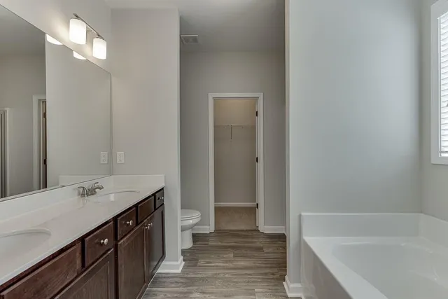a bathroom with a tub sink and a mirror