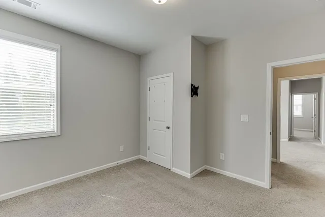 an empty room with windows and closet