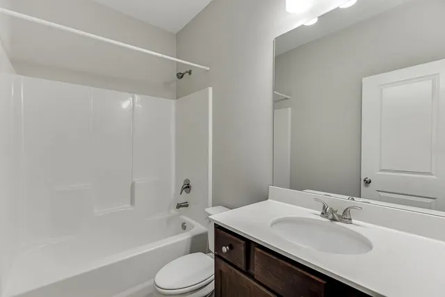 a bathroom with a bathtub shower sink and a toilet
