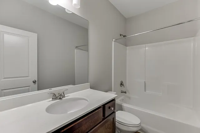 a bathroom with a sink toilet tub vanity and shower