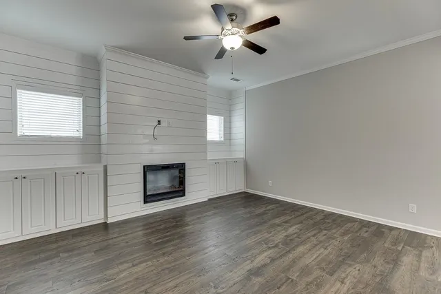 a view of an empty room with a fireplace and a window