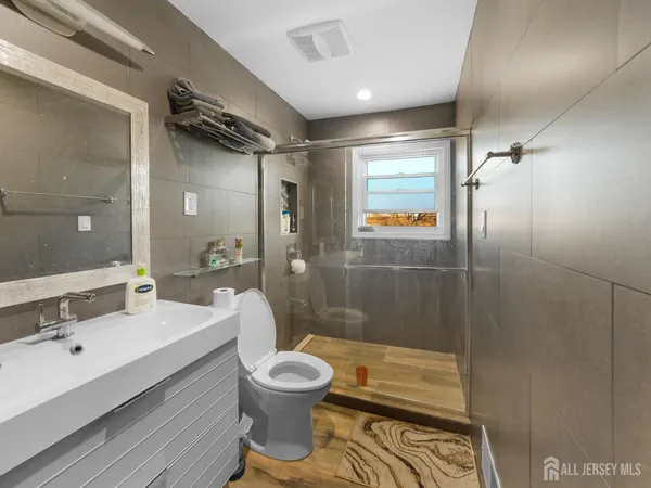 a bathroom with a sink mirror toilet and shower