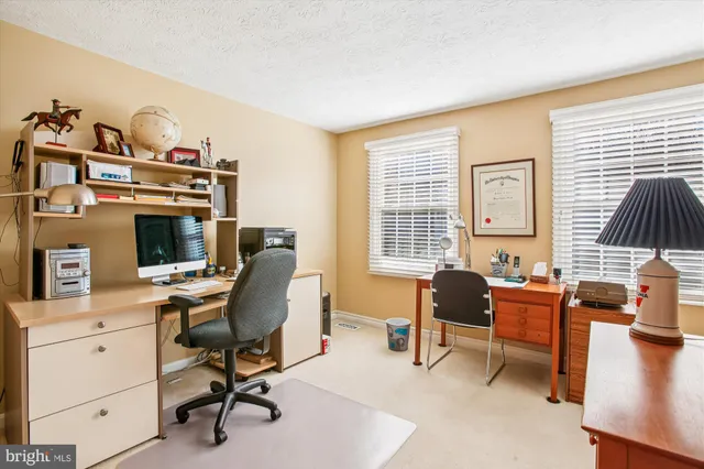 a view of a workspace with furniture and a window