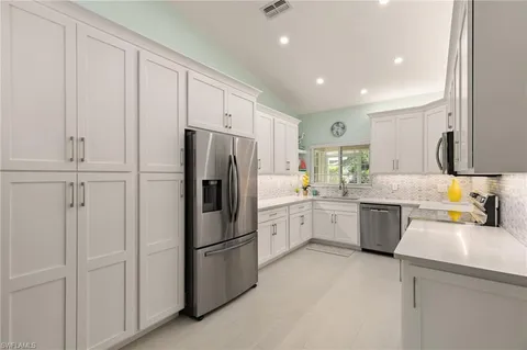 a kitchen with a refrigerator sink and cabinets