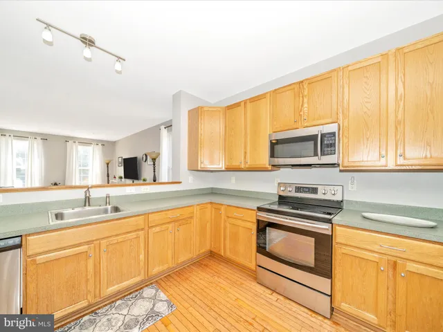 a kitchen with granite countertop a refrigerator stove top oven and sink
