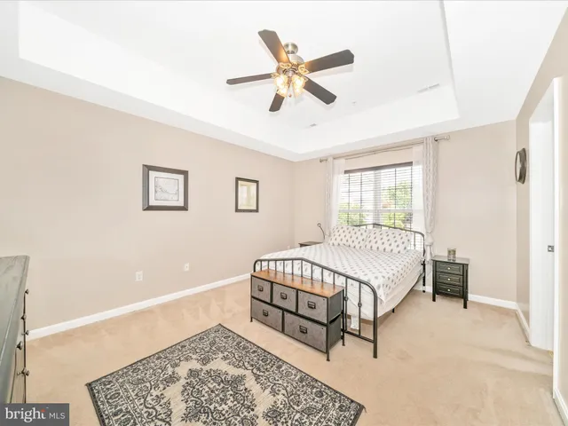 a bedroom with a large bed and a chandelier