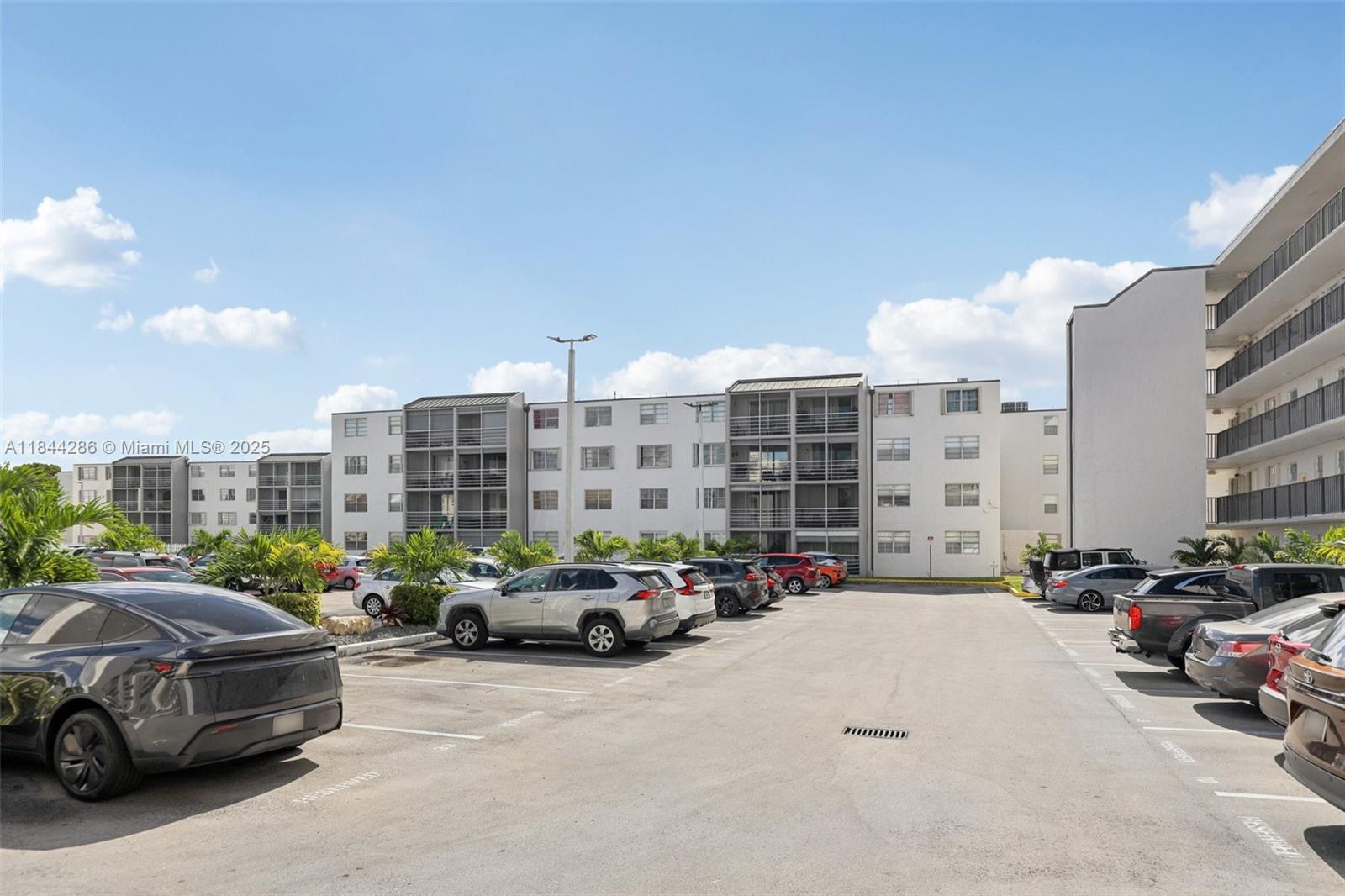 14170 Southwest 84th Street, Unit 501F Miami, FL 33183 - Photo 2 of 26 a city street lined with parked cars and buildings