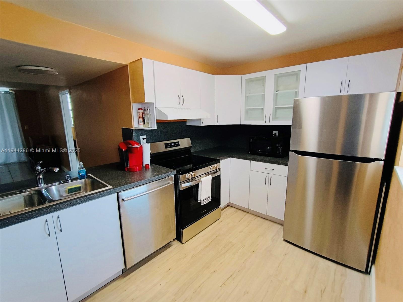 14170 Southwest 84th Street, Unit 501F Miami, FL 33183 - Photo 3 of 26 a kitchen with a sink a refrigerator and cabinets