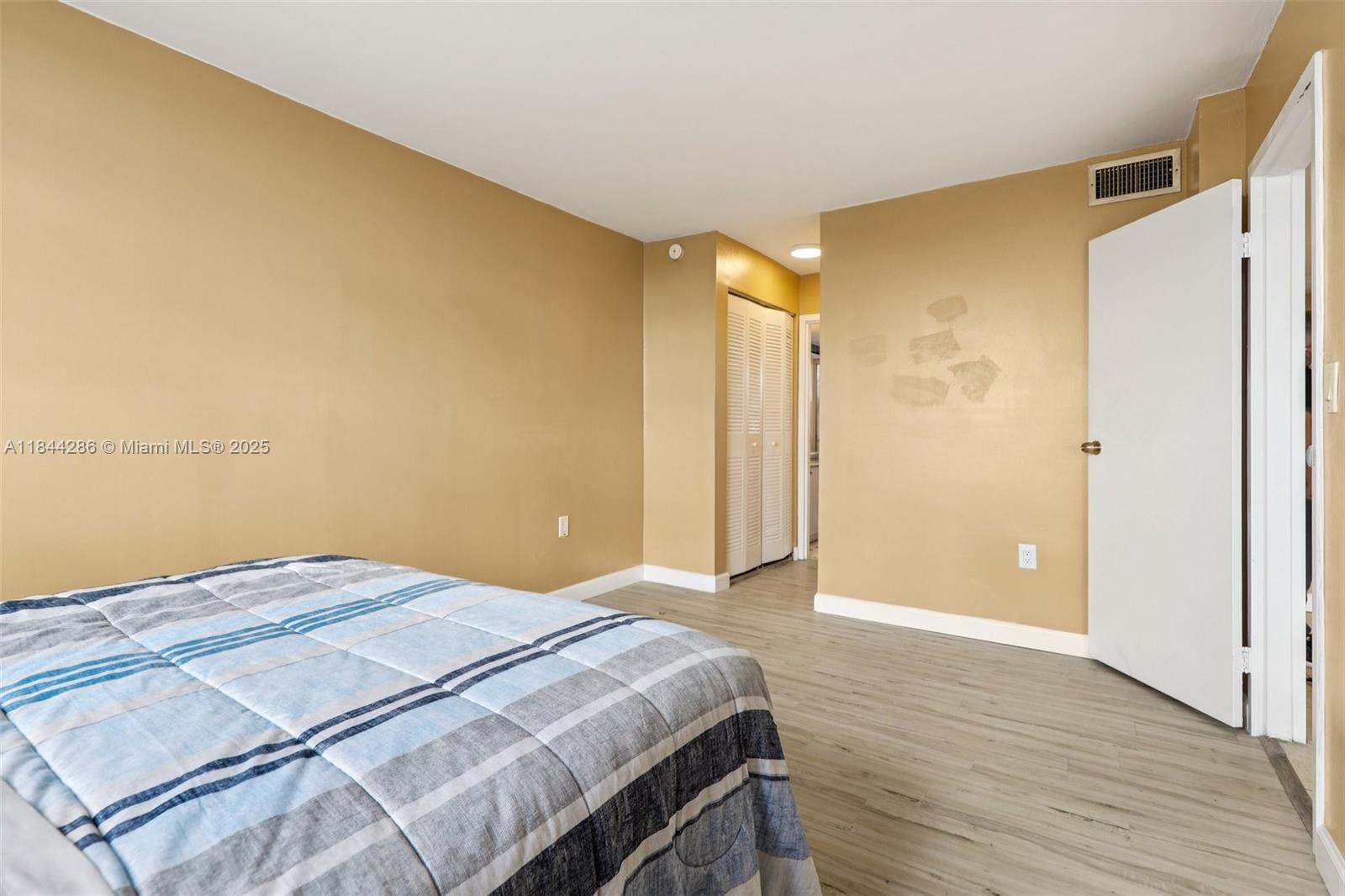 14170 Southwest 84th Street, Unit 501F Miami, FL 33183 - Photo 8 of 26 a bedroom with a bed and wooden floor