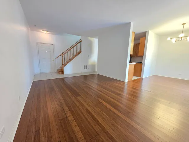 an empty room with wooden floor and door