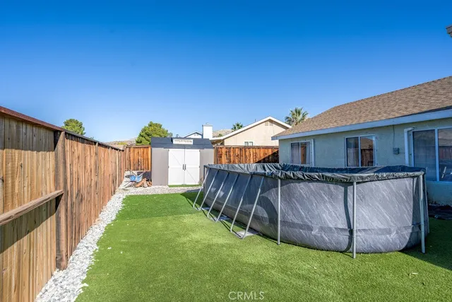 a view of a house with a yard and wooden fence