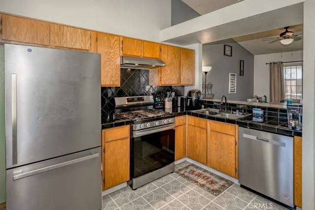 a kitchen with stainless steel appliances granite countertop a refrigerator and a sink