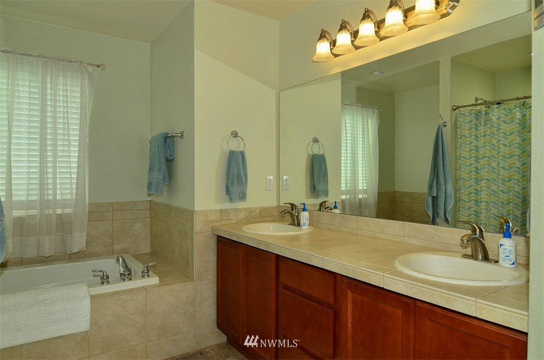 18110 Joseph Drive Southwest Rochester, WA 98579 - Photo 15 of 25 a bathroom with a sink tub double vanity and a mirror