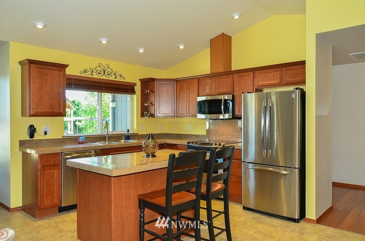 18110 Joseph Drive Southwest Rochester, WA 98579 - Photo 10 of 25 a kitchen with stainless steel appliances granite countertop a refrigerator a sink a stove a dining table and chairs