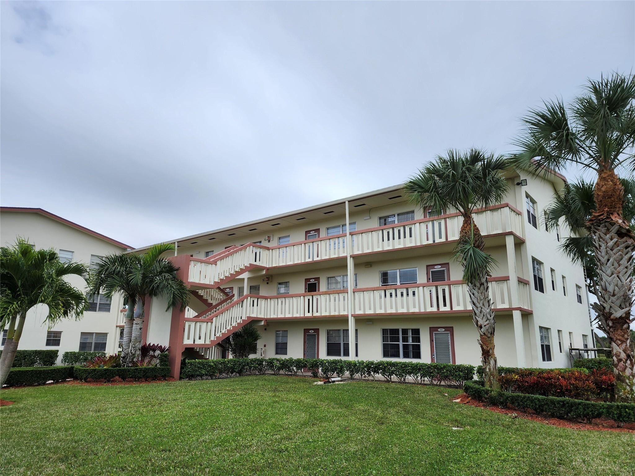 74 Preston Way Boca Raton, FL 33434 - Photo 1 of 28 a front view of a building with garden