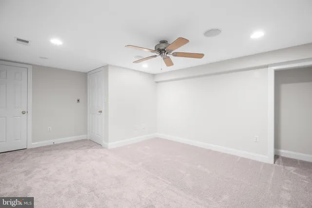 an empty room with closet and a ceiling fan