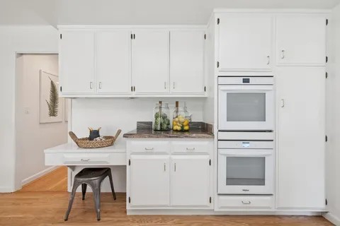 a kitchen with granite countertop white cabinets and appliances
