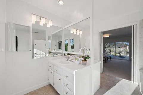 a bathroom with double vanity and a mirror