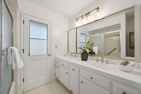 a bathroom with a double vanity sink and a mirror