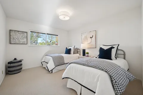 a bedroom with two beds and painting on the wall