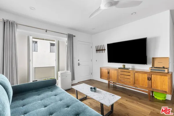 a living room with furniture and a wooden floor