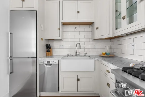 a kitchen with cabinets stainless steel appliances and wooden floor