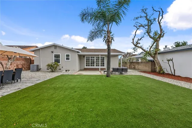 a view of a house with backyard and a tree
